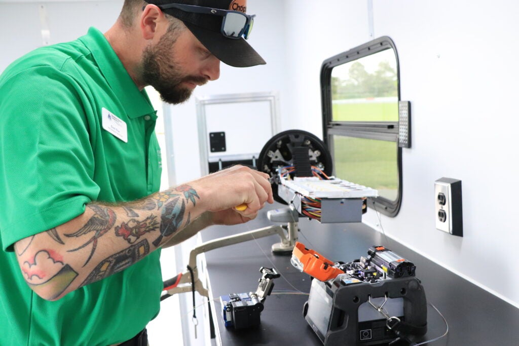 “Evan Roe, Choptank Fiber AMI Network Technician, carefully splicing fiber cables together in Choptank Fiber’s trailer. (Source: Choptank Electric Cooperative)”